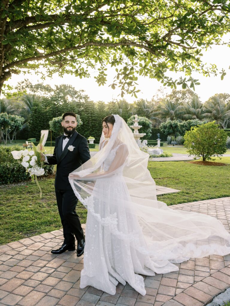 Bride and groom walking beneath the garden canopy at Cinco Farm wedding venue in Miami
