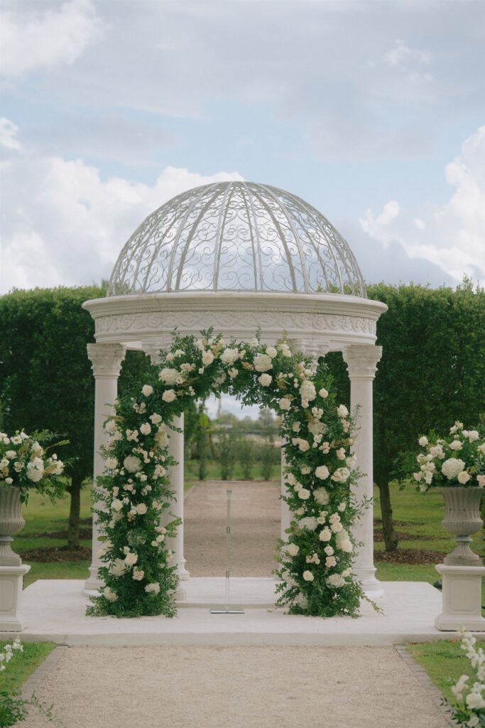 White gazebo with floral decor in the gardens at Cinco Farm in Miami