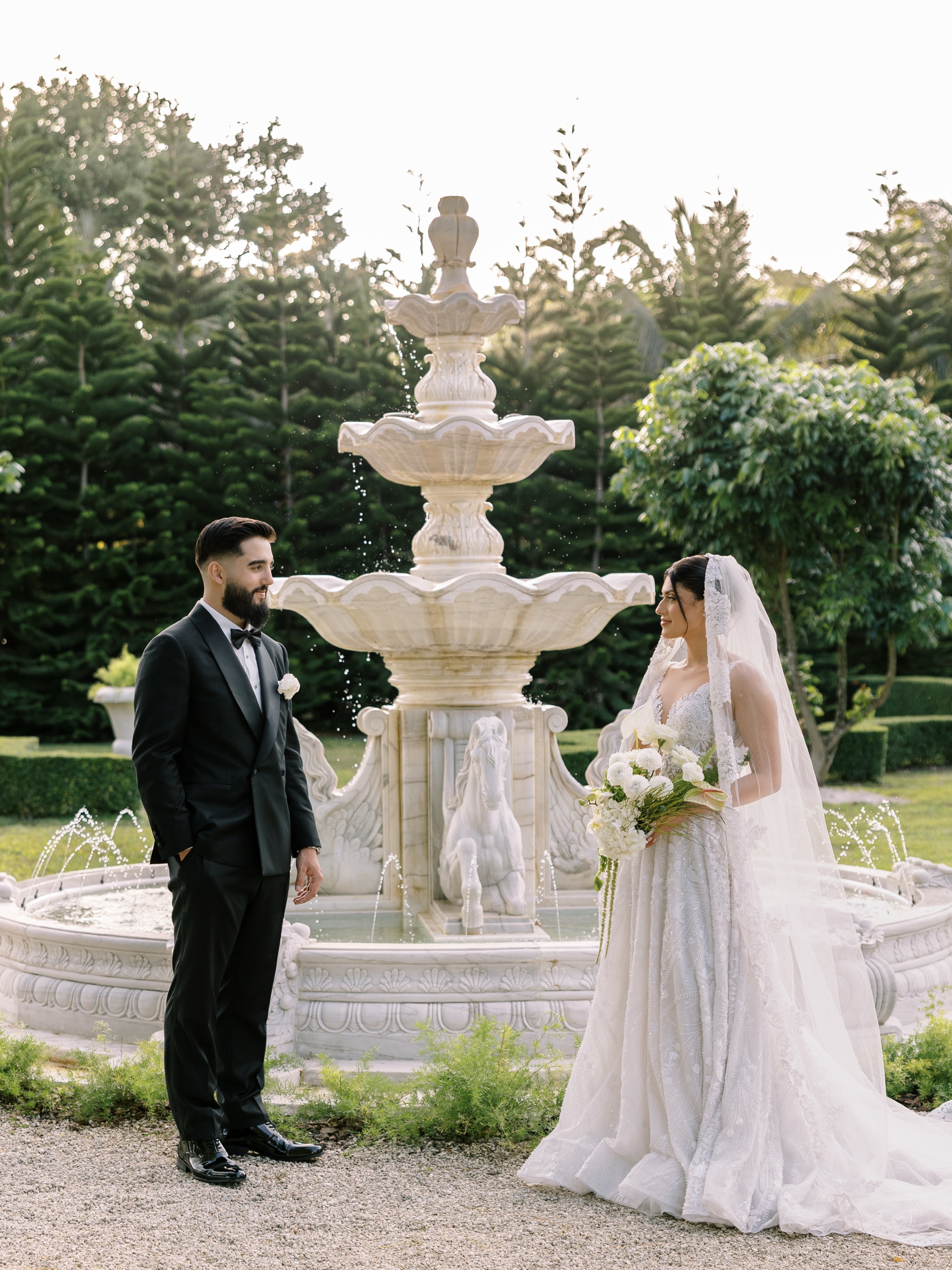 Bride and groom beside the garden fountain at Cinco Farm wedding venue in Miami