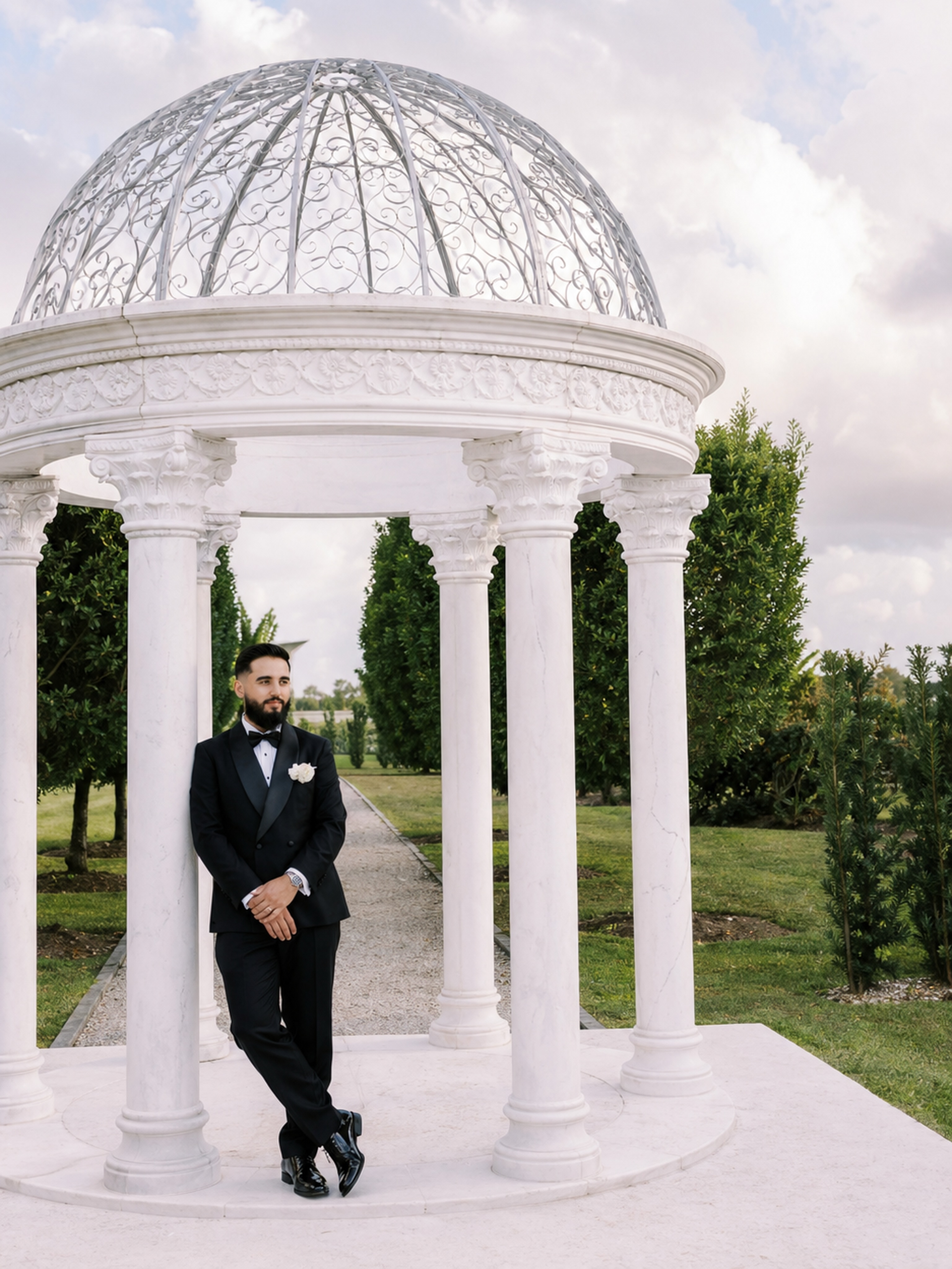 Groom standing inside the white garden gazebo at Cinco Farm in Miami