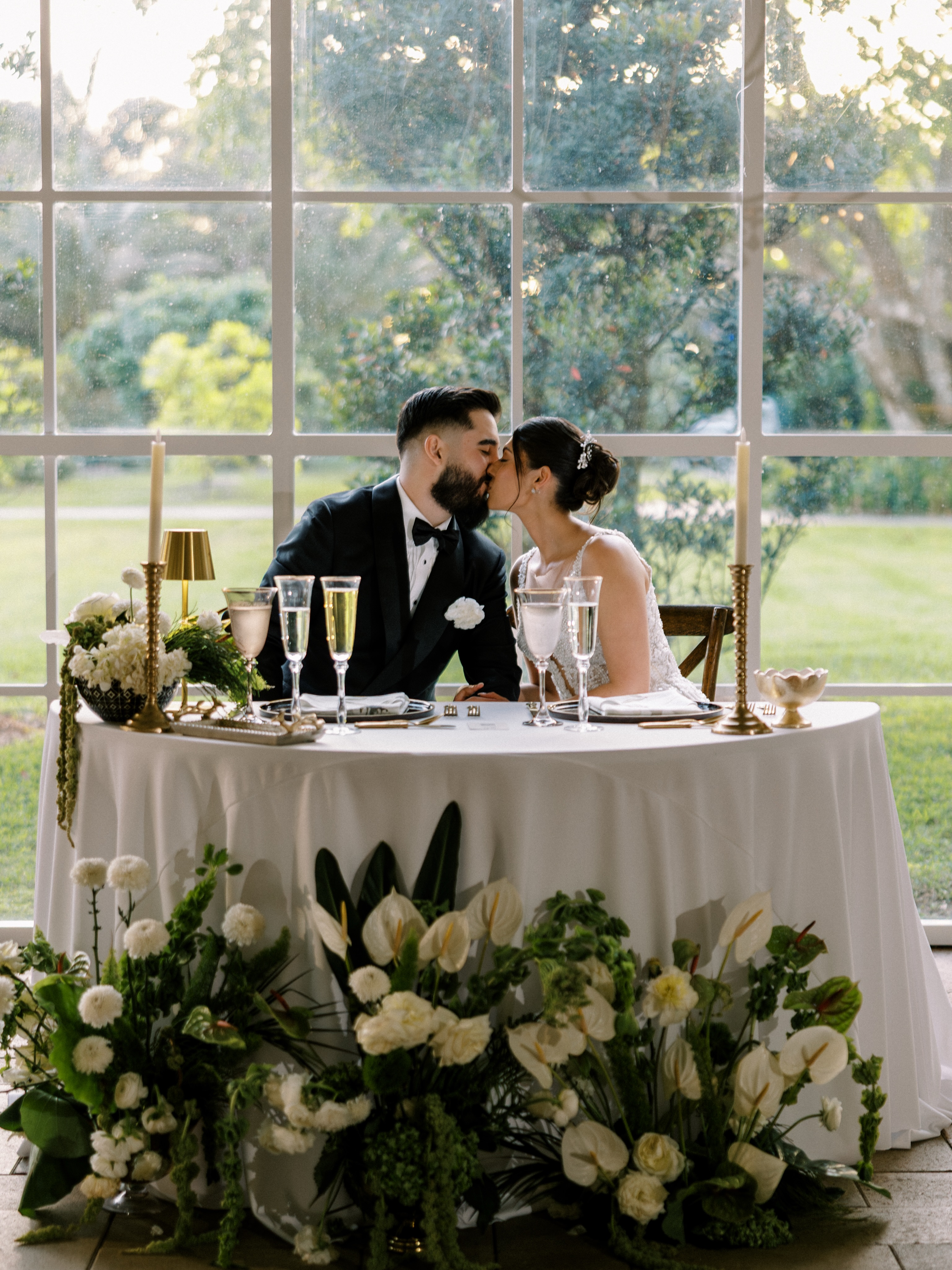 Newlyweds at an elegant sweetheart table inside Cinco Farm's garden reception pavilion
