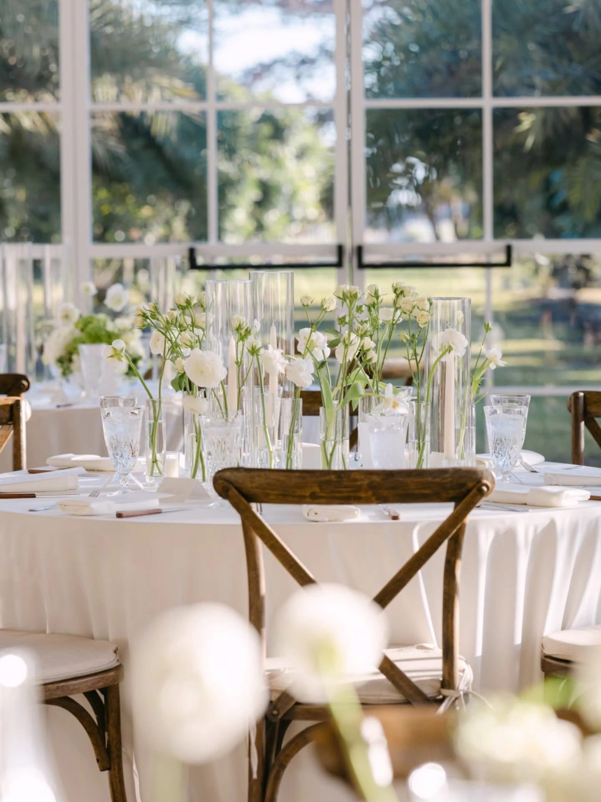 Elegant white wedding table with glass candle holders and fresh flowers at Cinco Farm