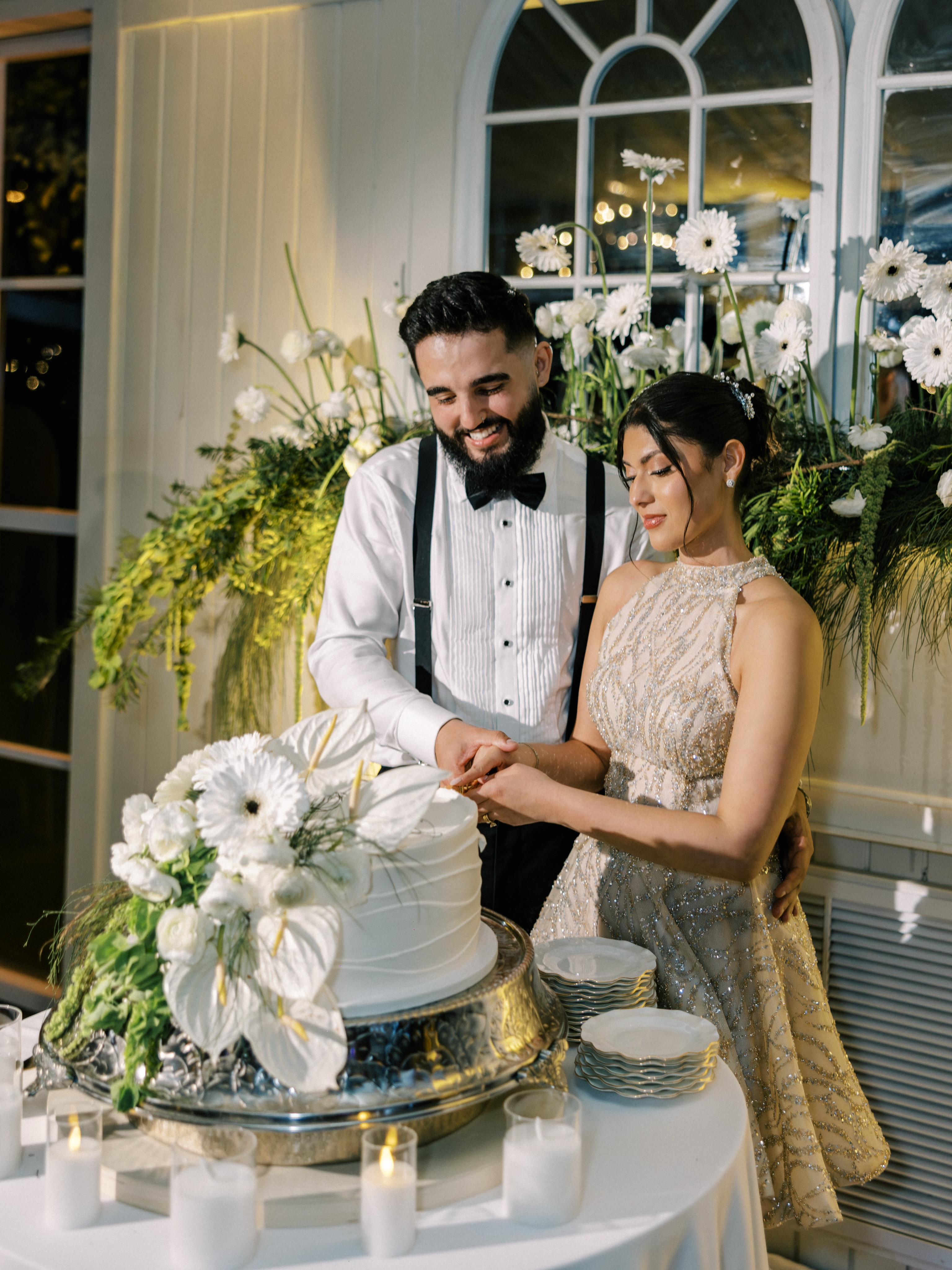 Newlyweds cutting an elegant white wedding cake at Cinco Farm in Miami